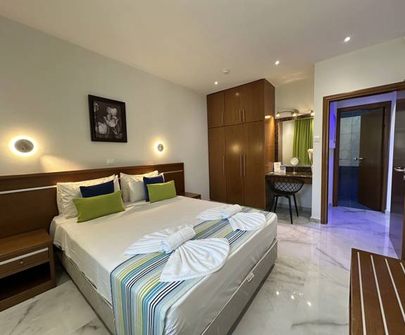 Loutsiana Hotel Deluxe One Bedroom Apt bedroom with decorated double bed and closet