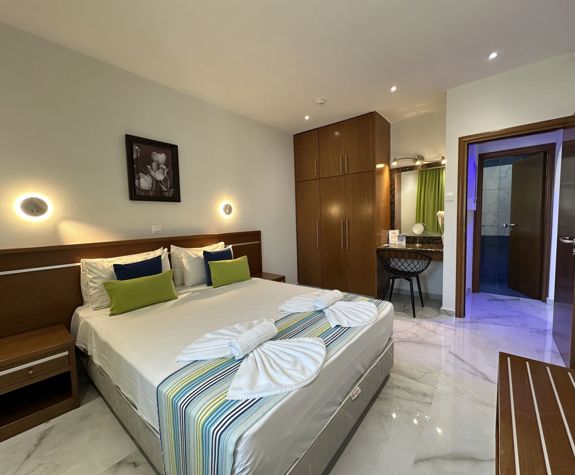 Loutsiana Hotel Deluxe One Bedroom Apt bedroom with decorated double bed and closet