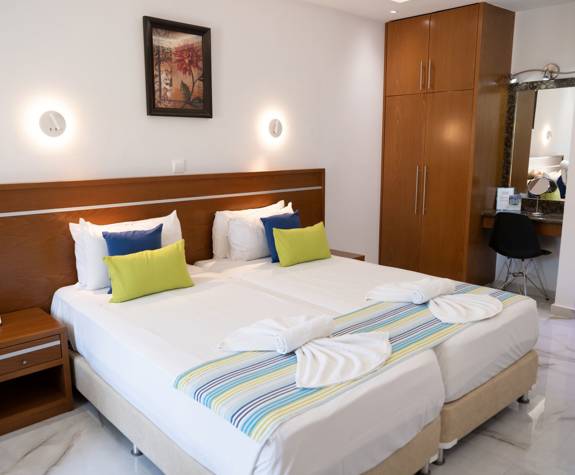 Loutsiana Hotel Deluxe Studio two single beds, a bedside table and a closet at the back